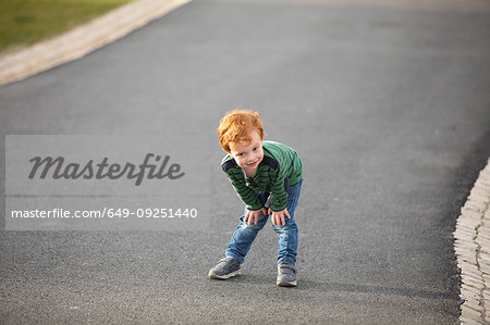 Boy stopping to rest on road