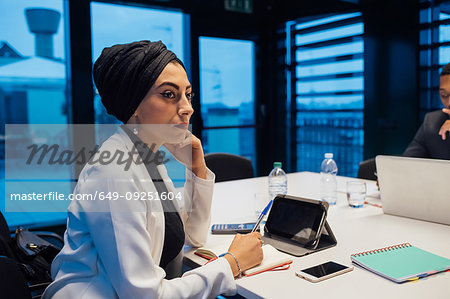 Businesswoman listening during conference table meeting