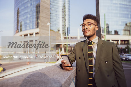 Businessman using smartphone on pavement, Milano, Lombardia, Italy