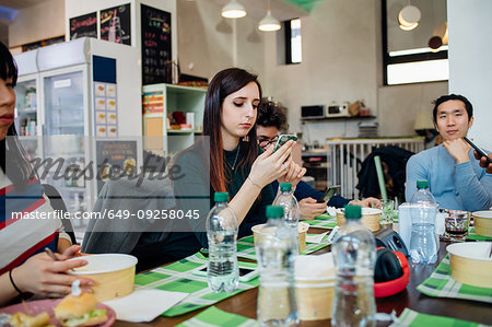 Male and female business team having working lunch at cafe table