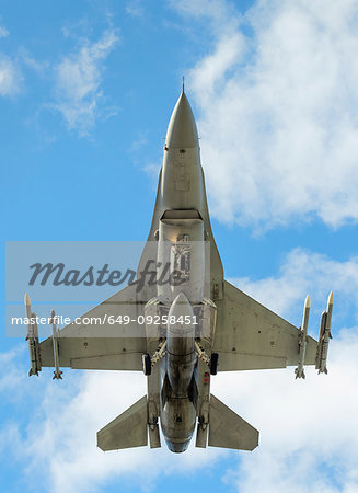Polish F-16 fighter plane taking part in NATO exercise Frysian flag, low angle against blue sky, Netherlands