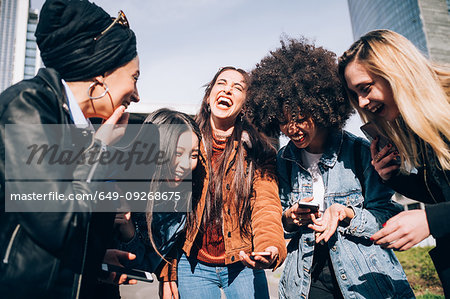 Friends laughing in street, Milan, Italy