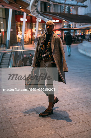 Stylish man walking through piazza, Milan, Italy