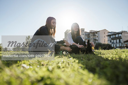 Sisters playing with dog in park
