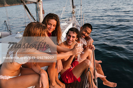 Friends toasting with champagne on sailboat, Italy