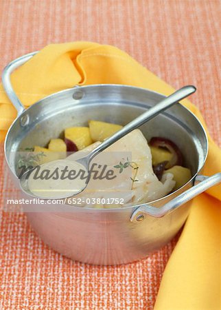 Casserole dish of cod and potatoes with mustard sauce