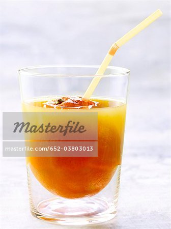 Glass of orange juice with a straw