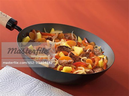 Pork,vegetables and pineapple cooked in a wok