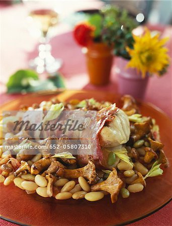 Monkfish wrapped in bacon with chanterelles and white beans