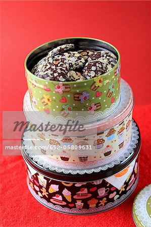 Tin boxes of cookies coated with chocolate and thinly sliced almonds