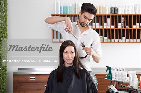 A Woman Having Her Hair Cut By A Male Hairdresser Stock Photo