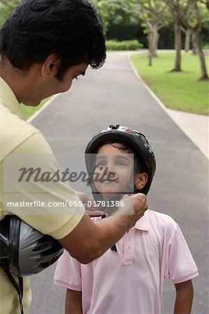 A father teaches his son to ride a bike