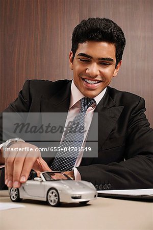 Businessman playing with toy car
