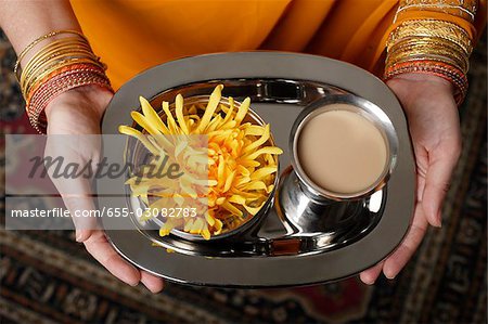 tight shot of woman holding a tray with tea.
