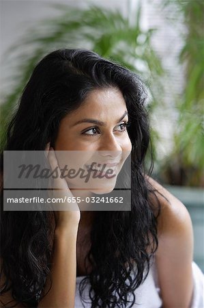 Profile of Indian woman smiling and touching her hair/