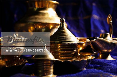 Still life of brass bowls and cups on table