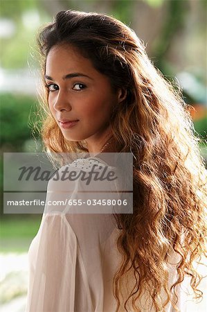 Young woman with long hair looking over her shoulder