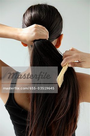 back shot of woman combing her long hair