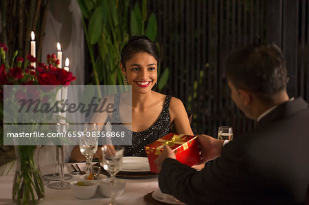 Singapore, Man giving gift box to woman at romantic dinner