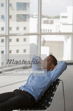 Singapore, Businessman reclining in chair in empty office