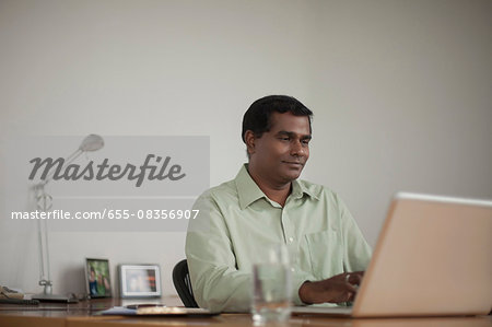 Singapore, Businessman using laptop at work