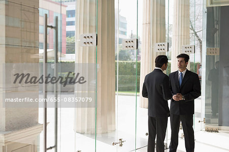 India, Businessmen talking in building lobby