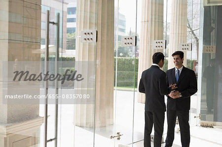 India, Businessmen talking in building lobby
