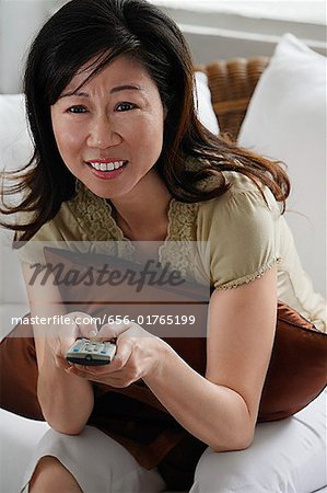 Woman holding TV remote control