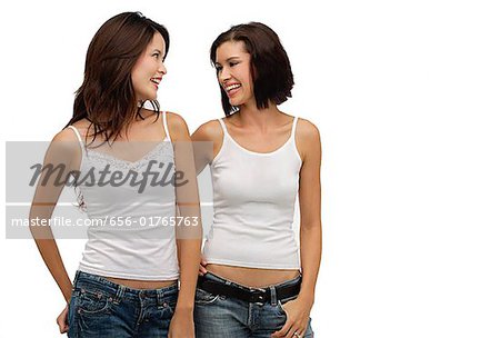 Two young women standing together and looking at each other