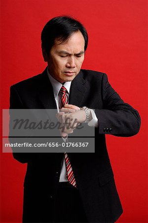 A businessman checks his watch for the time