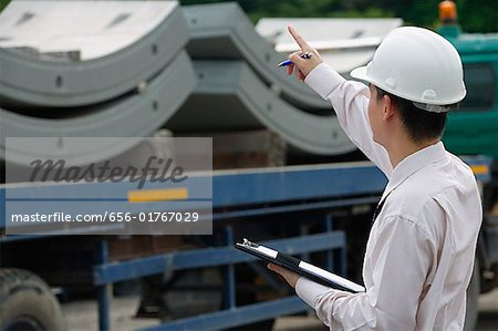 Man with hard helmet and clipboard