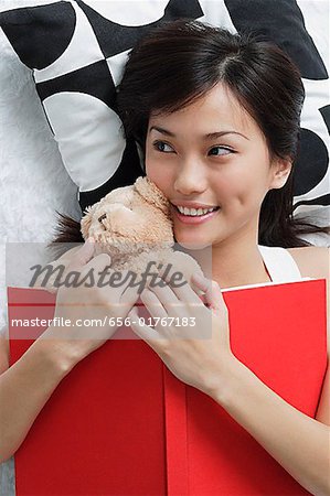 Young woman with teddy and book