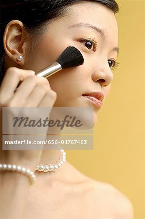 Woman putting on blusher with make up brush