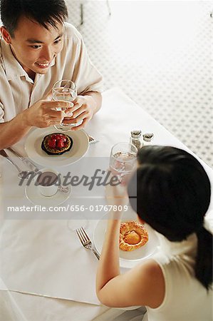 Couple sitting opposite each other at cafe, high angle view