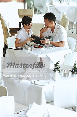 Couple in restaurant, holding menu