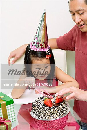 Happy father blowing candles on cake while celebrating birthday with his  cute little daughter Stock Photo by insidecreativehouse