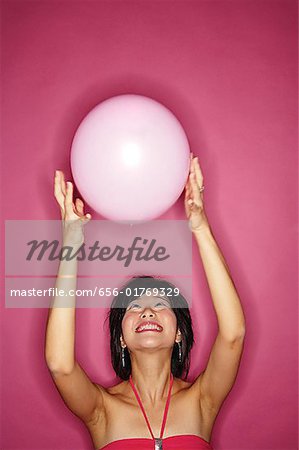 Woman tossing pink balloon