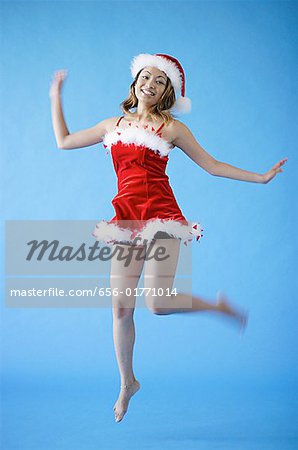 Woman in Santa hat and red dress, jumping