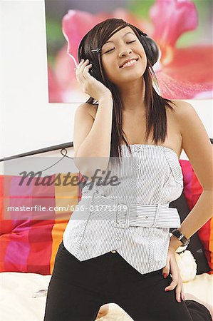 Girl standing, listening to headphones