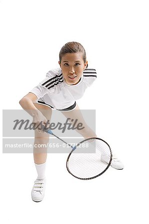 Young woman playing badminton, studio shot