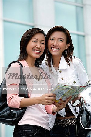 Two women with map, smiling at camera