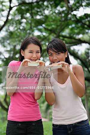 Two women eating ice cream, looking at camera