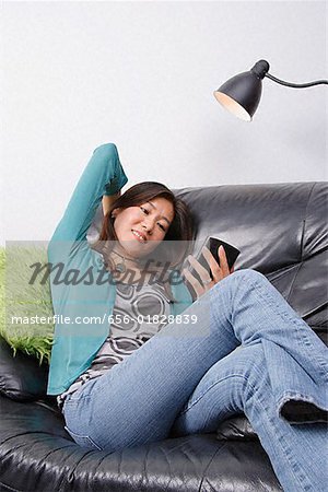 Young woman sitting in couch looking at organizer