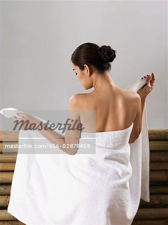 https://image1.masterfile.com/getImage/656-02879459em-woman-wrapping-herself-in-towel-stock-photo.jpg