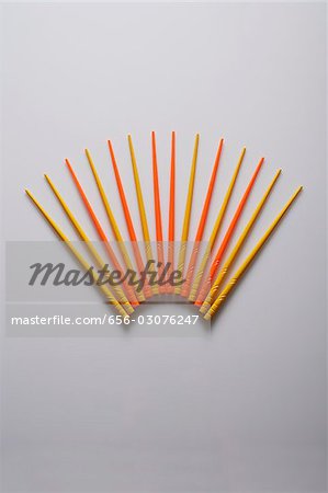 Orange and yellow chopsticks in the shape of a fan.