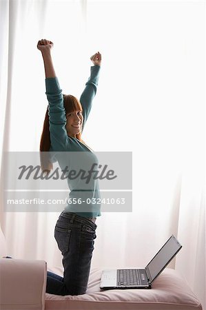 Asian girl stretching at home with laptop