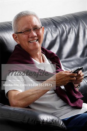 mature man with grey hair smiling holding a phone