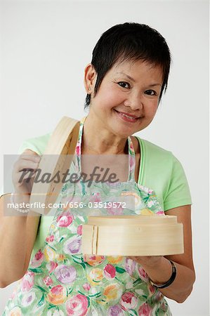 Mature Chinese woman holding bamboo steamer