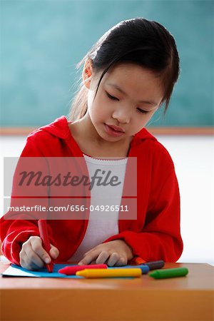 Young girl coloring with crayons