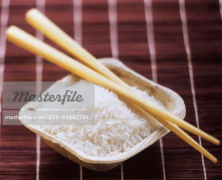 A Dish of Uncooked White Rice with Chopsticks